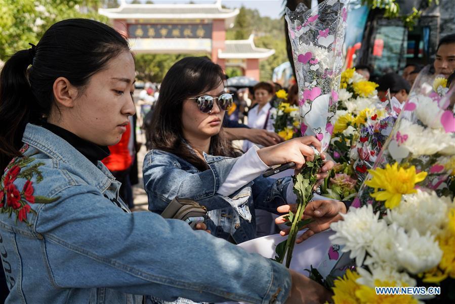 People present bouquets during a spontaneous mourning ceremony to pay tribute to those who lost their lives while fighting the forest fire in a funeral parlour in Xichang City, southwest China\'s Sichuan Province, April 2, 2019. A fire that killed 30 people and engulfed about 15 hectares of forest in southwest China\'s Sichuan Province was extinguished Tuesday, local authorities said. Thirty people, including 27 firefighters and three locals, lost their lives while fighting the fire. (Xinhua/Zhang Chaoqun)