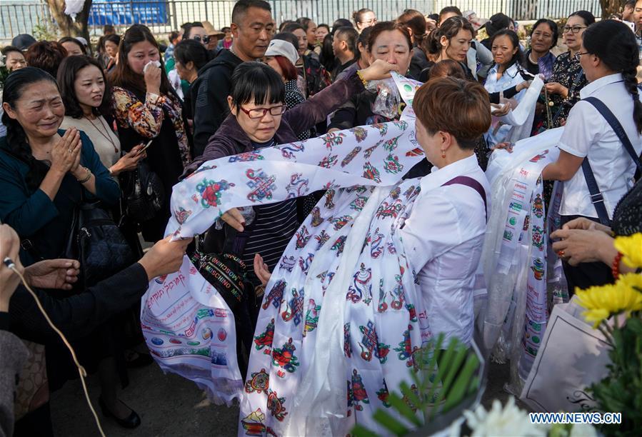 People present hada, a ceremonial silk cloth to show respect, during a spontaneous mourning ceremony to pay tribute to those who lost their lives while fighting the forest fire in a funeral parlour in Xichang City, southwest China\'s Sichuan Province, April 2, 2019. A fire that killed 30 people and engulfed about 15 hectares of forest in southwest China\'s Sichuan Province was extinguished Tuesday, local authorities said. Thirty people, including 27 firefighters and three locals, lost their lives while fighting the fire. (Xinhua/Zhang Chaoqun)