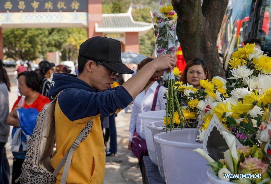 A citizen presents a bouquet during a spontaneous mourning ceremony to pay tribute to those who lost their lives while fighting the forest fire in a funeral parlour in Xichang City, southwest China\'s Sichuan Province, April 2, 2019. A fire that killed 30 people and engulfed about 15 hectares of forest in southwest China\'s Sichuan Province was extinguished Tuesday, local authorities said. Thirty people, including 27 firefighters and three locals, lost their lives while fighting the fire. (Xinhua/Zhang Chaoqun)