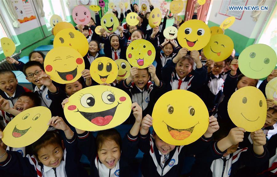 Pupils demonstrate smiley cards to greet the upcoming World Smile Day at a primary school in Handan, north China\'s Hebei Province, May 7, 2019. World Smile Day is celebrated on May 8 every year. (Xinhua/Hao Qunying)