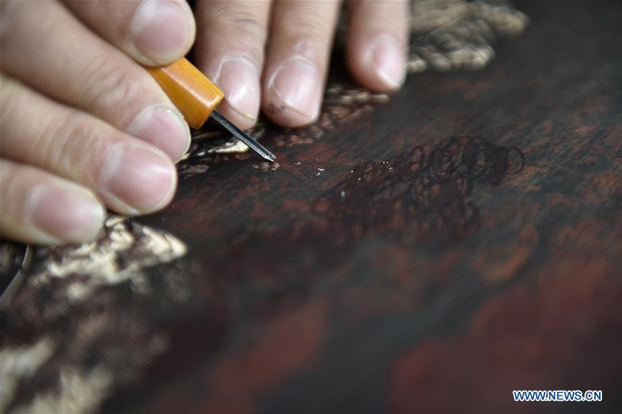 Chen Dongming works on a wood-block painting at his studio in Huanren County of Benxi, northeast China\'s Liaoning Province, May 27, 2019. Chen Dongming, a 52-year-old wood-block painter from Wafang Village of Huanren County in Benxi, learned the techniques from his grandfather since young. As an inheritor of Huanren wood-block painting, a provincial intangible cultural heritage in Liaoning, Chen has been committed to making a proper integration of traditional Chinese landscape paintings and wood-block New Year paintings to promote the craft in an innovative way. (Xinhua/Yao Jianfeng)