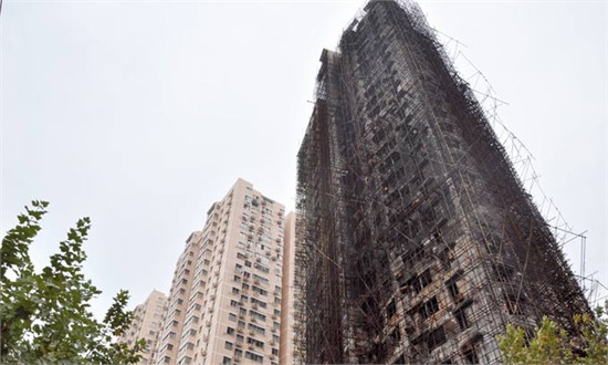 The charred remains of 728 Jiaozhou Road remain covered in scaffolding as restoration work on the blacked concrete structure continues. Photos: Global Times