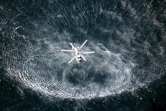 A helicopter tries to save a fisherman during a joint exercise by civilian maritime authorities and the Peoples Liberation Army Navy in the East China Sea on Friday. [Zhang Lei / For China Daily]