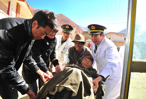 Dr Li Suzhi helps carry a patient on Oct 27, 2012 in Dagze county, Lhasa, Tibet autonomous region. [Photo/Xinhua] 