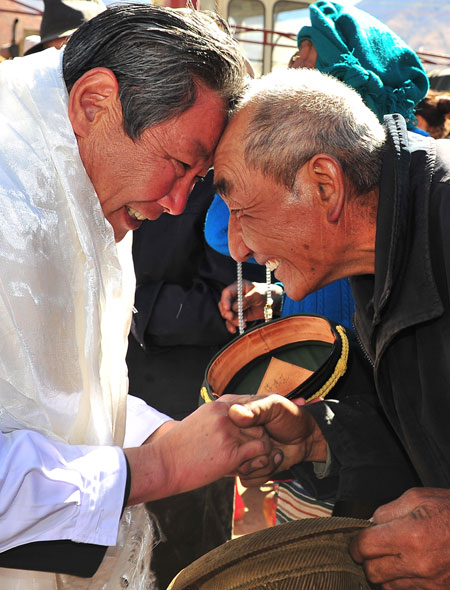 A former patient of Dr Li Suzhi shakes his hand and gives him a salute by touching his forehead on Oct 27, 2012 in Dagze county, Lhasa, Tibet autonomous region. [Photo/Xinhua] 