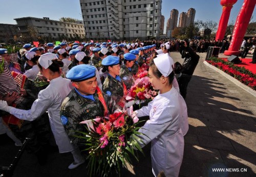 Members of the medical team of the 14th batch of Chinese peacekeeping force for Liberia receive flowers during a departure ceremony in Tianjin, north China, Nov. 13, 2012. The first batch of a 43-member Chinese medical personnel group left for Liberia on a eight-month UN peacekeeping mission here on Tuesday. (Xinhua/Zhang Chaoqun) 