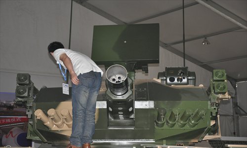 A staff member looks at a 30-millimeter caliber 6-barrel mobile Gatling gun on display at Airshow China 2012. The gun can fire a curtain of bullets to destroy cruise missiles and aircraft. Photo: Xu Tianran/GT