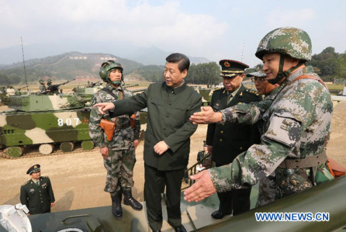 General Secretary of the Communist Party of China (CPC) Central Committee Xi Jinping (C), who is also the chairman of the CPC Central Military Commission, examines an armored vehicle at the Guangzhou military theater of operations of the People's Liberation Army (PLA), Dec. 10, 2012. Xi made an inspection at the PLA's Guangzhou military theater of operations, a term usually used to emphasize the coordination and joint operations by forces in air, land and sea, from Dec. 8 to 10. (Xinhua/Wang Jianmin)