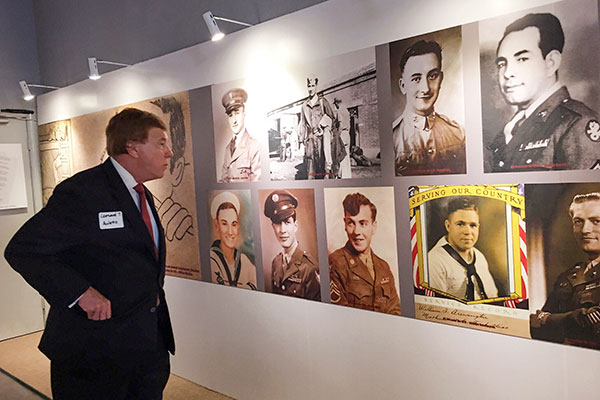 A visitor studies photographs of Allied prisoners of war at an exhibition titled Forgotten Camp about the Shenyang World War II Allied POW Camp, known back then as Mukden, Nov. 21, 2017. The traveling exhibit is on display through Dec 5 in San Francisco, the first stop in North America. (HANG YUAN/CHINA DAILY)