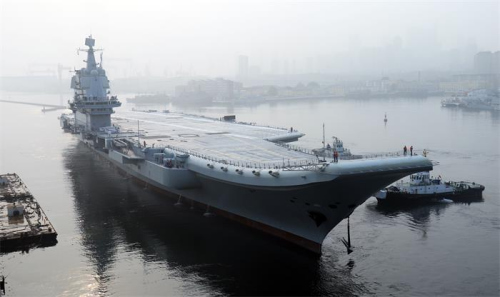 Chinas first domestically designed aircraft carrier, which displaces 50,000 metric tons, leaves the Dalian Shipbuilding Industrys shipyard in Liaoning province on Sunday. (LI GANG/FOR CHINA DAILY)