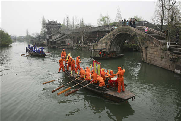 Crisscrossing waterways are now the biggest draw for visitors to Wuzhen, Zhejiang province. Visitors stroll along the banks or hop aboard boats to take in the views. (Photo by Shi Kuihua/For China Daily)