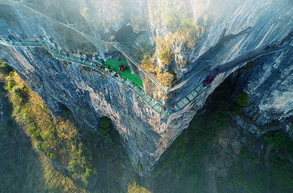 Passes built on the cliffs and a glass suspension bridge are among the highlights of Zhusha ancient town in Guizhou, which has turned from mercury mine site to a tourist hot spot. (Photo provided to China Daily)