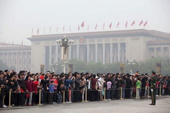 Tourists gather to watch the flag-raising ceremony at Tian'anmen Square during the three-day May Day holiday in Beijing, on May 1, 2012. [Photo: Xinhua]