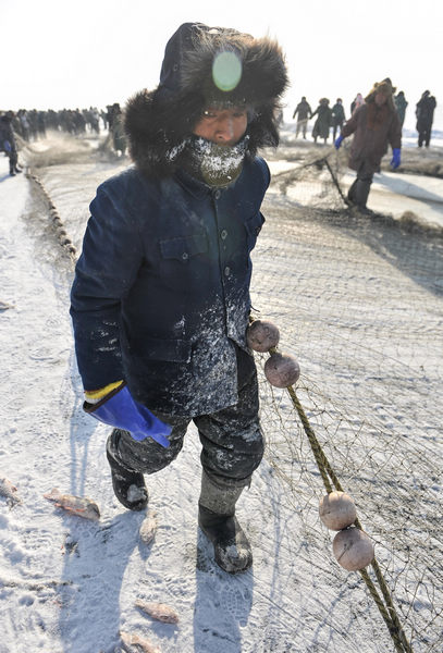 A fisherman dresses up warm to take part in a winter fishing event on Chagan Lake, Jilin province.[Photos by Bai Shi / For China Daily]