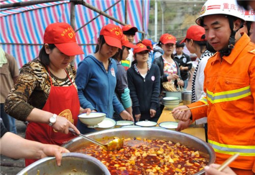 Volunteers carry relief materials in Longmen township, Ya'an city, April 23, 2013. [Photo/Xinhua]