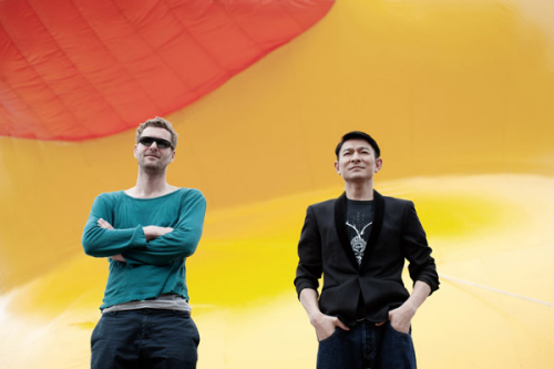 Hong Kong actor Andy Lau and Dutch artist Florentijn Hofmans (L) pose in front of Hofmans installation Rubber Duck in Hong Kong, April 29, 2013. [Photo/Icpress] 