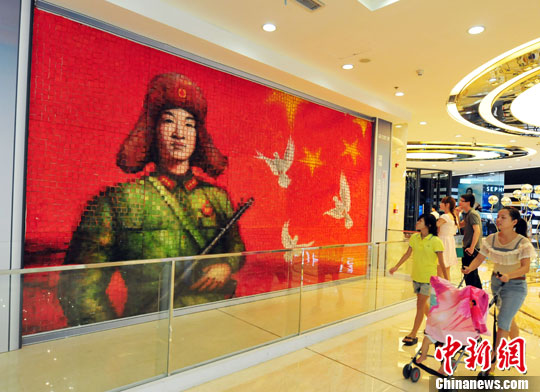 A massive painting on toast featuring Lei Feng, the nation´s most famous Good Samaritan, is put on display in a commercial plaza in Fuzhou, capital of East China's Fujian Province Thursday, July 11, 2013. The painting made with 2,500 slices of toast is created by a professional art team. (Photo: CNS/Wang Dongming)