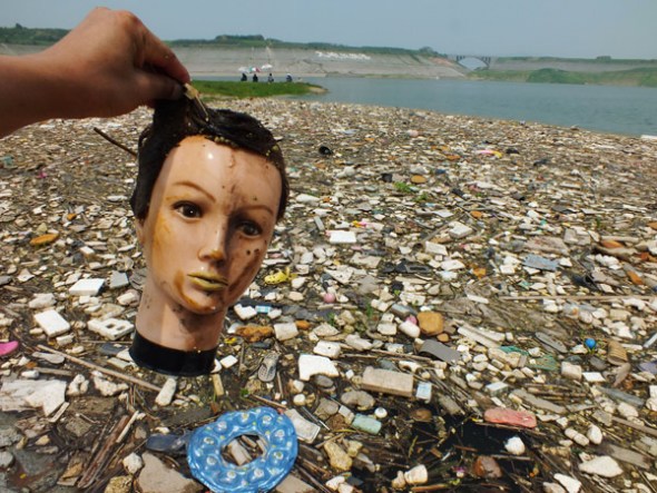 The head of a dummy is picked up from floating garbage on Yangtze River in the upper reaches of Three Gorges Dam, in Yichang, Central China's Hubei province on July 15, 2013. The garbage was brought by seasonal flooding, overwhelming the local cleanup crews and creating massive floating-trash zones on Yangtze River.[Photo by Liujunfeng/Asianewsphoto]