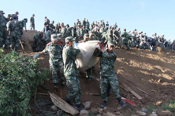 Soldiers carry the body of a victim in Yongguang village, Minxian county, July 22, 2013. [Photo/Xinhua]