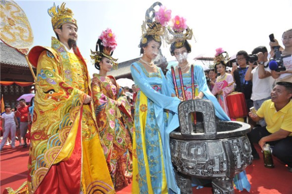 A couple dress as Emperor and Queen in their Tang Dynasty (AD 618-907)-style wedding in Xi'an, Shaanxi province, on Aug 13, 2013. [Photo by Yuan Jingzhi/Asianewsphoto]