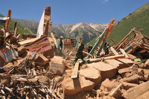 Rescue workers search for people amid collapsed houses toppled by a 6.1-magnitude earthquake on Monday in Mizha village, Tibet autonomous region, Aug 13, 2013. [Photo/Asianewsphoto]