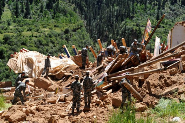 Rescue workers clean a collapsed house toppled by a 6.1-magnitude earthquake on Monday in Mizha village, Tibet autonomous region, Aug 13, 2013. [Photo/Xinhua]