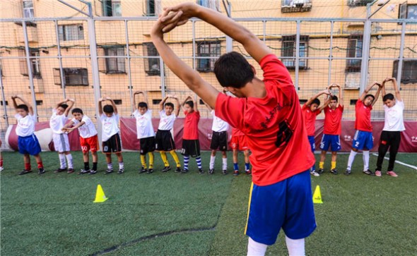 Student soccer players from Urumqi Fifth Primary School defy the formidable heat to train in Urumqi, Xinjiang Uygur autonomous region train on Aug 13. The team defended its title at the National Teenage Campus Soccer Championship 2013 in Guangzhou, South China's Guangdong province between July 15-18, before it swept all other teams with 43 goals and only 3 losses at the International Youth Soccer Tournament, held in Weifang city of China's Shandong province.[Photo/Xinhua]