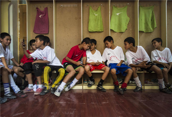 Student soccer players chat in a changing room in Urumqi Fifth Primary School, Urumqi city of Xinjiang Uygur autonomous region, Aug 13. [Photo/Xinhua]