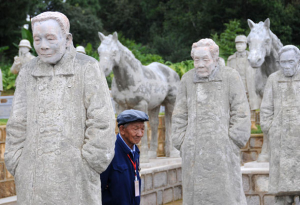 A veteran from the Chinese Expeditionary Force walks by sculptures of soldiers while attending an event marking the 68th anniversary of victory in the War of Resistance against Japanese Aggression (1937-45), in Songshan Mountain, Longling county, Yunnan province, Sept 3, 2013. The anniversary was also marked by the official opening of a memorial park on top of the mountain, complete with 402 sculptures of soldiers from the Chinese Expeditionary Force, which helped defeat Japanese forces during the conflict. The replica army has 12 different divisions, including child soldiers, infantry and artillery troops. [Photo/Xinhua]