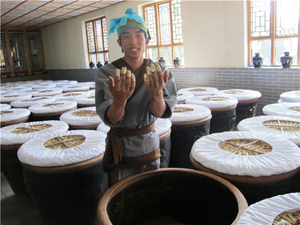 Copper finger caps are used during the brewing process at Baoyuan Vinegar Workshop in Qingxu county, North China's Shanxi province, Sept 5, 2013. [Photo by Guo Rong/chinadaily.com.cn]