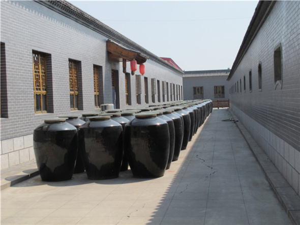 Vats with mature vinegar are placed in the yard for aging at Baoyuan Vinegar Workshop in Qingxu county, North China's Shanxi province, Sept 5, 2013. [Photo by Guo Rong/chinadaily.com.cn]