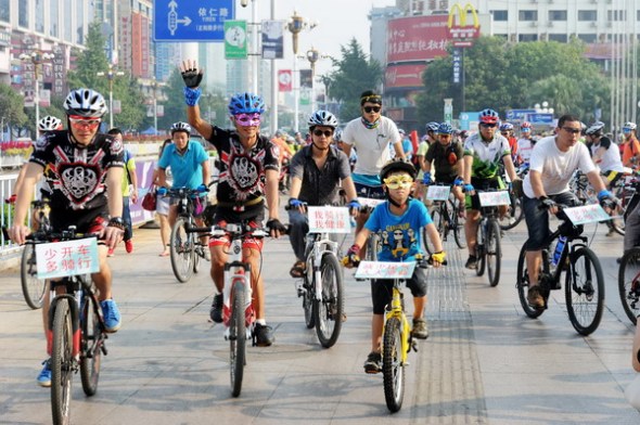 Volunteers ride bikes to promote low-carbon travel in Guilin city, South China's Guangxi Zhuang autonomous region, Sept 21, 2013. With the year's theme Green Transport & Clean Air, 153 Chinese cities have taken part in World Car Free Day campaign and people are encouraged to take public transport, ride bikes or walk. The campaign first originated in France in 1998 and initiatively launched in China in 2007, aiming to promote environment-friendly transport and ease the city's traffic congestion. [Photo/Xinhua]