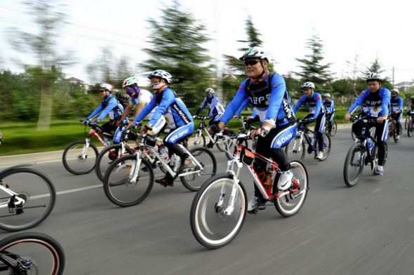 Volunteers ride bikes to promote low-carbon travel in Suqian city, East China's Jiangsu province Sept 21, 2013. [Photo/Xinhua]