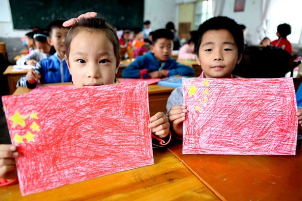 Young students scribble national flags to celebrate the 64th National Day of China, in Bozhou city, East China's Anhui province, Sept 24, 2013. [Photo/Asianewsphoto]