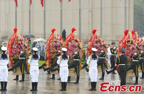 Soldiers carry the flower baskets in rain at the Monument to the People's Heroes in Tian'anmen Square of Beijing, Oct 1, 2013, the National Day of China. (Photo: Liu Zhen / China News Service)