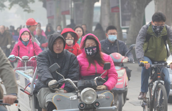 Commuters wear masks amid heavy smog in Jinan, East China's Shandong province, Oct 29. [Photo by Zheng Tao/Asianewsphoto]