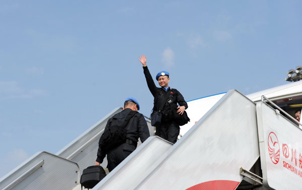 Zhang Jun (R), a female member of the peacekeeping team, waves goodbye to her family and friends at Chengdu Shuangliu International Airport, Nov 12, 2013. [Photo by He Haiyang/Asianewsphoto]