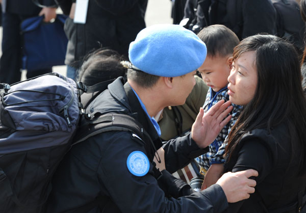 A policeman says goodbye to his wife and son at Chengdu Shuangliu International Airport, Nov 12, 2013. [Photo by He Haiyang/Asianewsphoto]