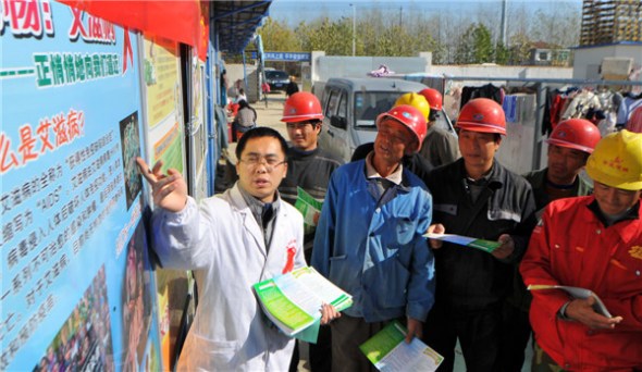 A doctor explains HIV to construction workers in Hefei, capital city of Anhui province, Nov 29, 2013. [Photo by Ge Chuanhong/Asianewsphoto]