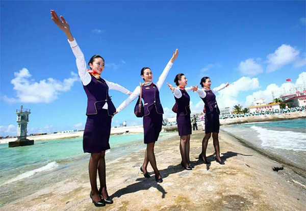 Stewardesses stretch their arms to the sky while celebrating the successful test flights of two Chinese commercial airliners on Jan 6 at a newly built airfield in the Nansha Islands in the South China Sea. (Photo/Xinhua)