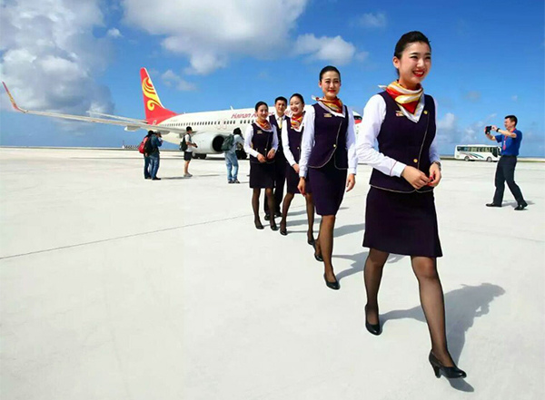 Stewardesses walk out of a Chinese aircraft that landed on the newly constructed runway at Yongshu Jiao in China's Nansha Islands during a test flight on Jan 6. (Photo/Xinhua)