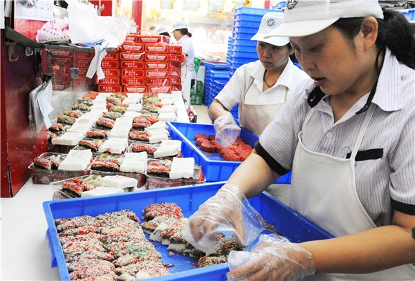 Staff members sell traditional Double Ninth cakes in Suzhou on the Double Ninth Festival, which falls on Oct 9, 2016. (Photo/Asianewsphoto)