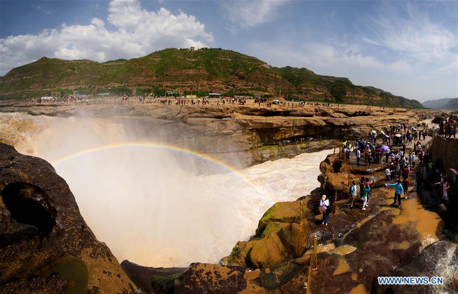Tourists view Hukou Waterfall of Yellow River in NW China