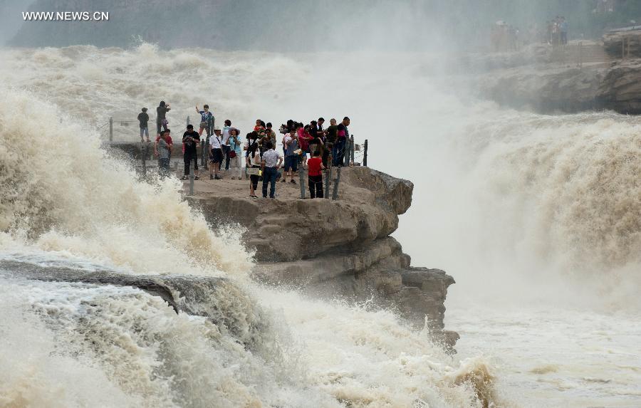 
People gather to watch the Hukou Waterfall of the Yellow River in Yichuan  County, northwest China\'s Shaanxi Province, June 2, 2014. (Xinhua/Liu Xiao)