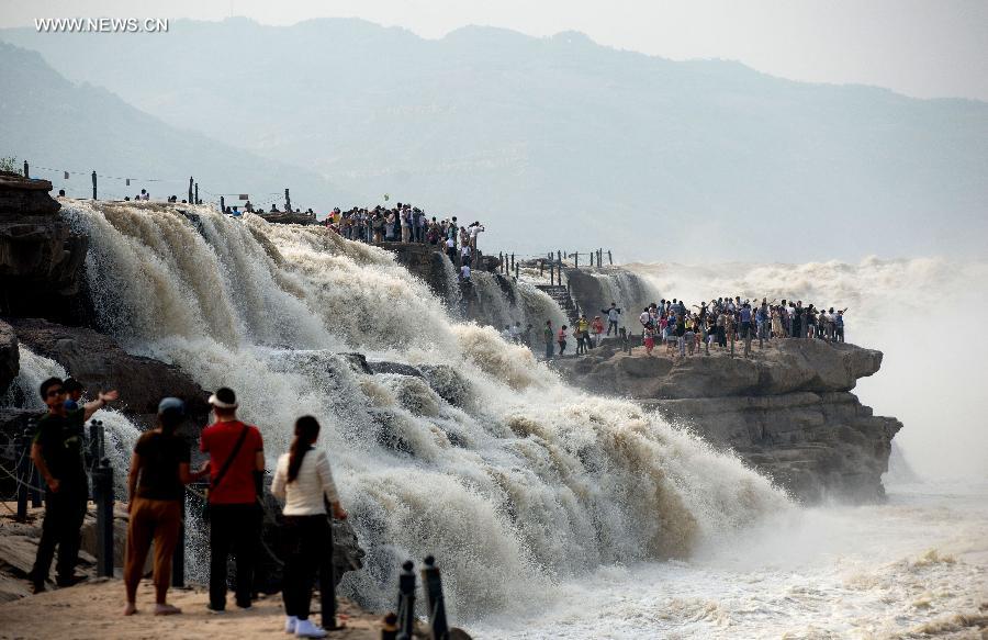 
People gather to watch the Hukou Waterfall of the Yellow River in Yichuan  County, northwest China\'s Shaanxi Province, June 2, 2014. (Xinhua/Liu Xiao)