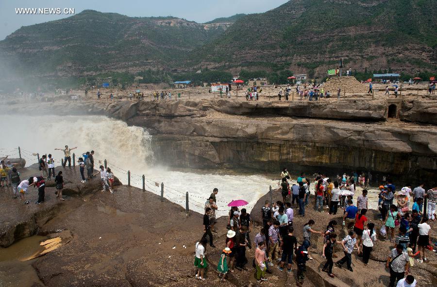 
People gather to watch the Hukou Waterfall of the Yellow River in Yichuan  County, northwest China\'s Shaanxi Province, June 2, 2014. (Xinhua/Liu Xiao)