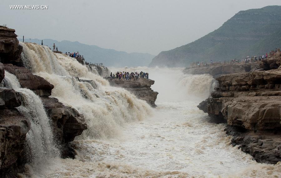 
People gather to watch the Hukou Waterfall of the Yellow River in Yichuan  County, northwest China\'s Shaanxi Province, June 2, 2014. (Xinhua/Liu Xiao)