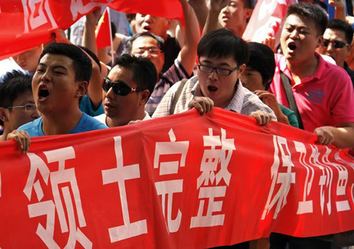 Demonstrators hold banners (territorial integrity and protection of Diaoyu Islands in Chinese) and chant slogans as they protest outside the Japanese embassy in Beijing on Wednesday. David Gray / Reuters