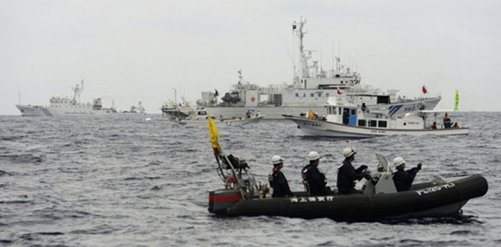 Chinese marine surveillance ship Haijian No. 46(L) tries to approach towards Japanese fishing boats (2nd and 3rd from front) while a Japan Coast Guard boat sails (front), in the East China Sea, near Diaoyu islands, in this photo taken by Kyodo May 26, 2013. [Photo/Agencies]