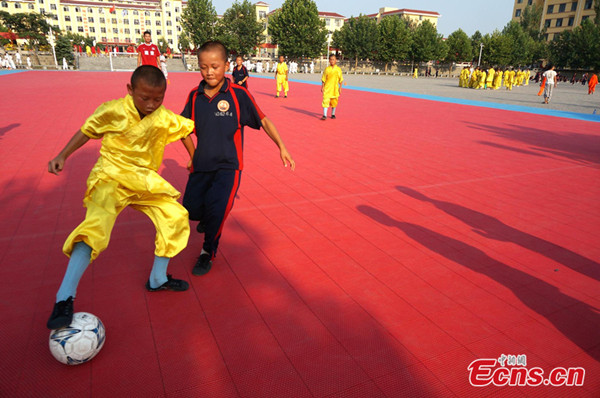 Soccer team members perform daily exercise at Songshan Shaolin warrior monks' training base in central China's Henan province on August 13, 2013. According to the head coach of the training base, they began the Shaolin Kung Fu soccer team in 2011 and now there are more than 500 team members, aging between 8 and 15. [Photo: CNS/Zhou Xiaoyun]